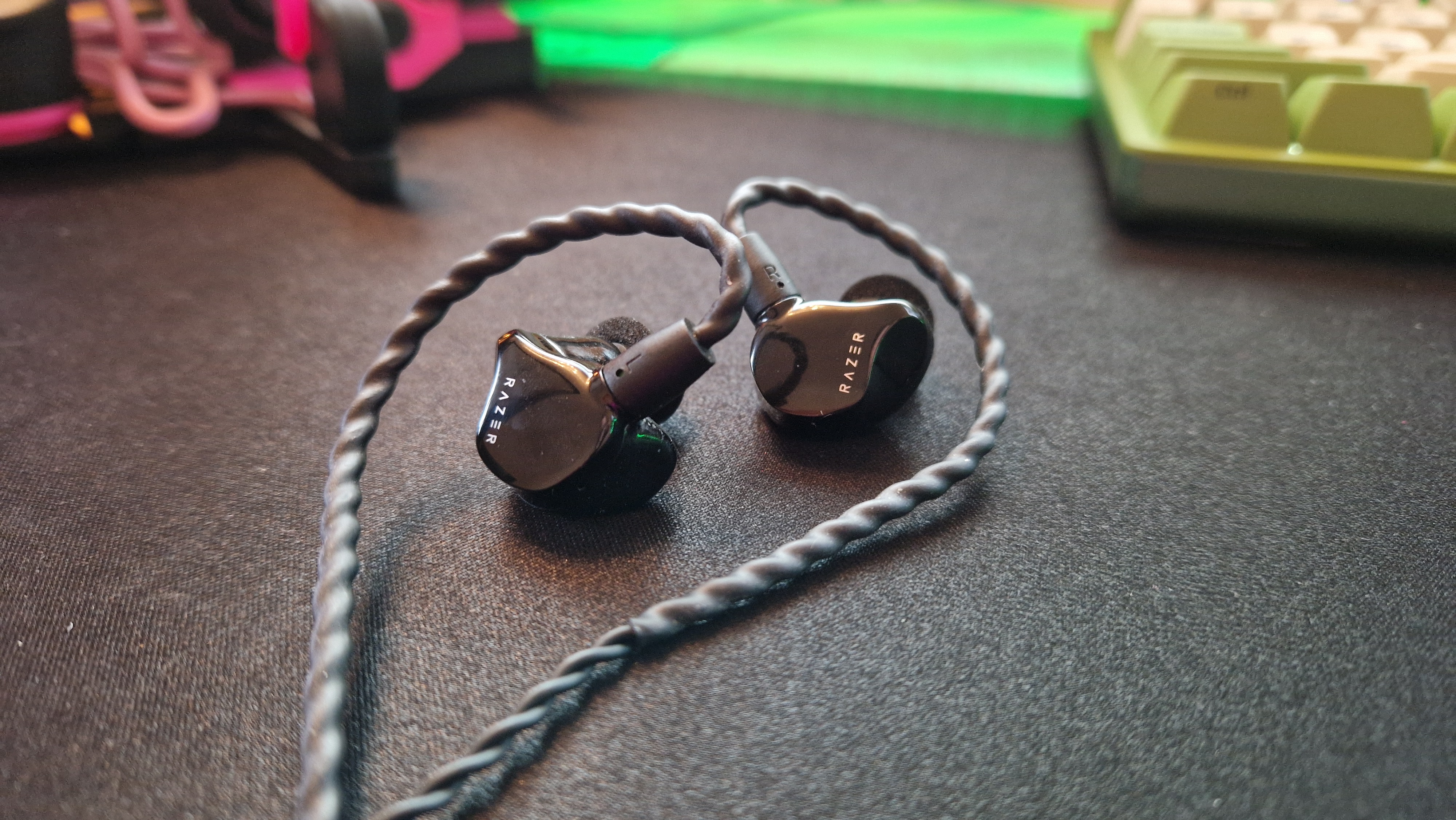 Razer Moray review image of the in-ear monitors lying on a black desk mat
